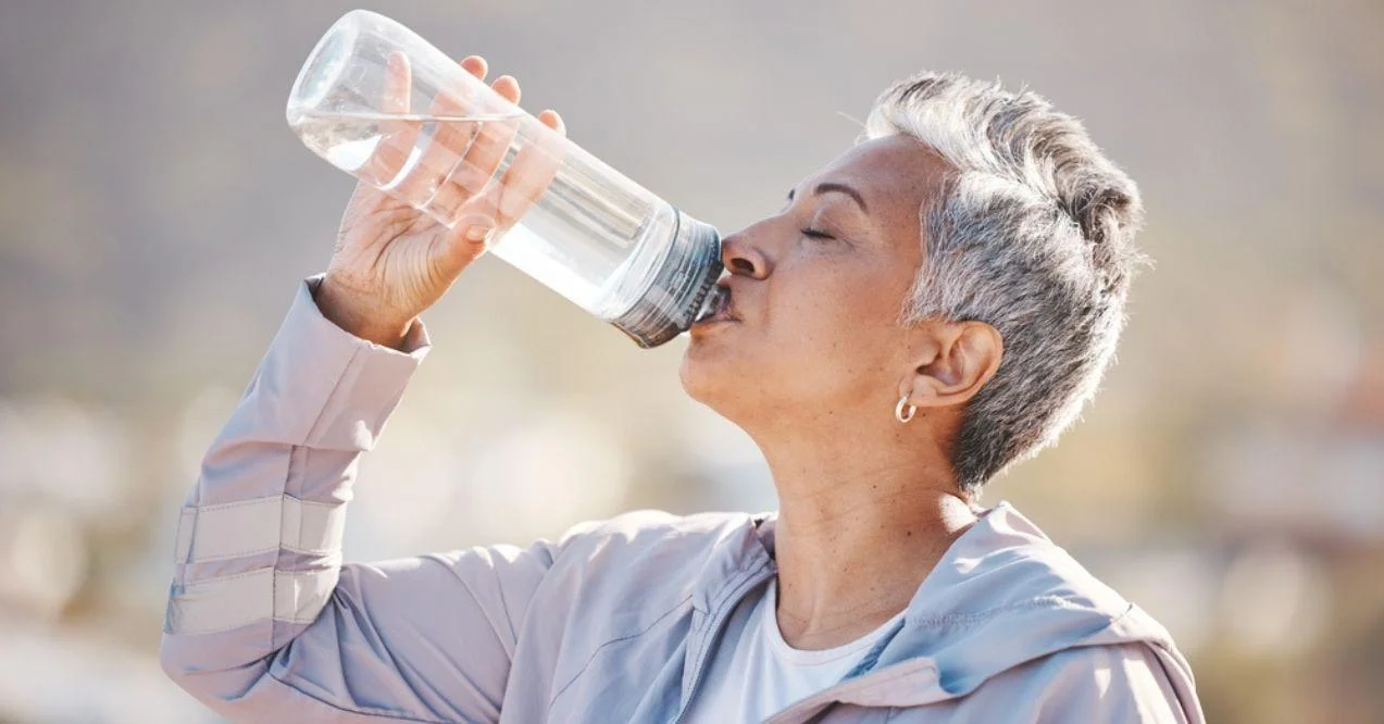 Senior woman hydrating in the outside