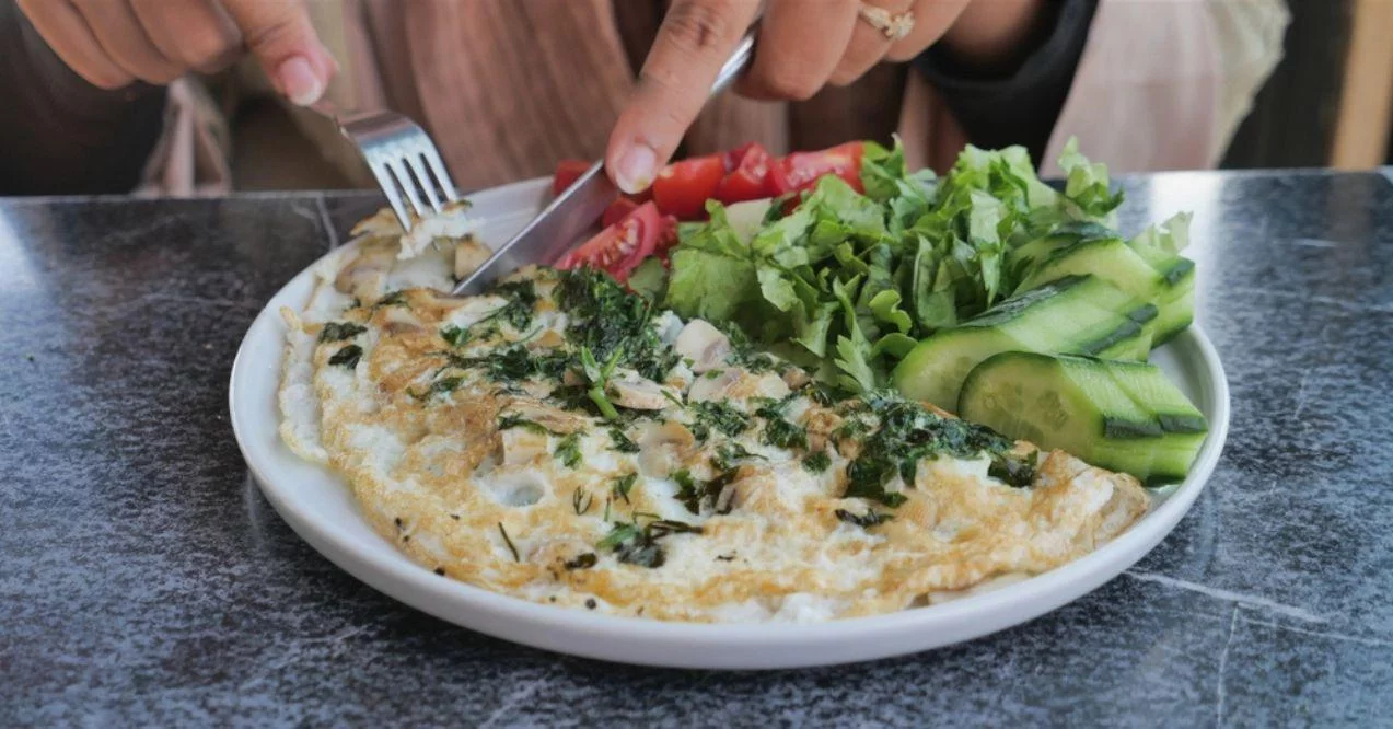 Eating plain egg omelette on table