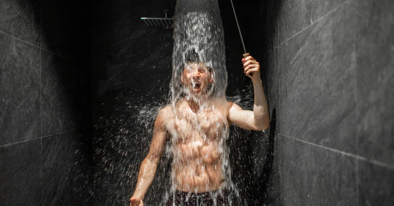 A man is soaking himself in cold water