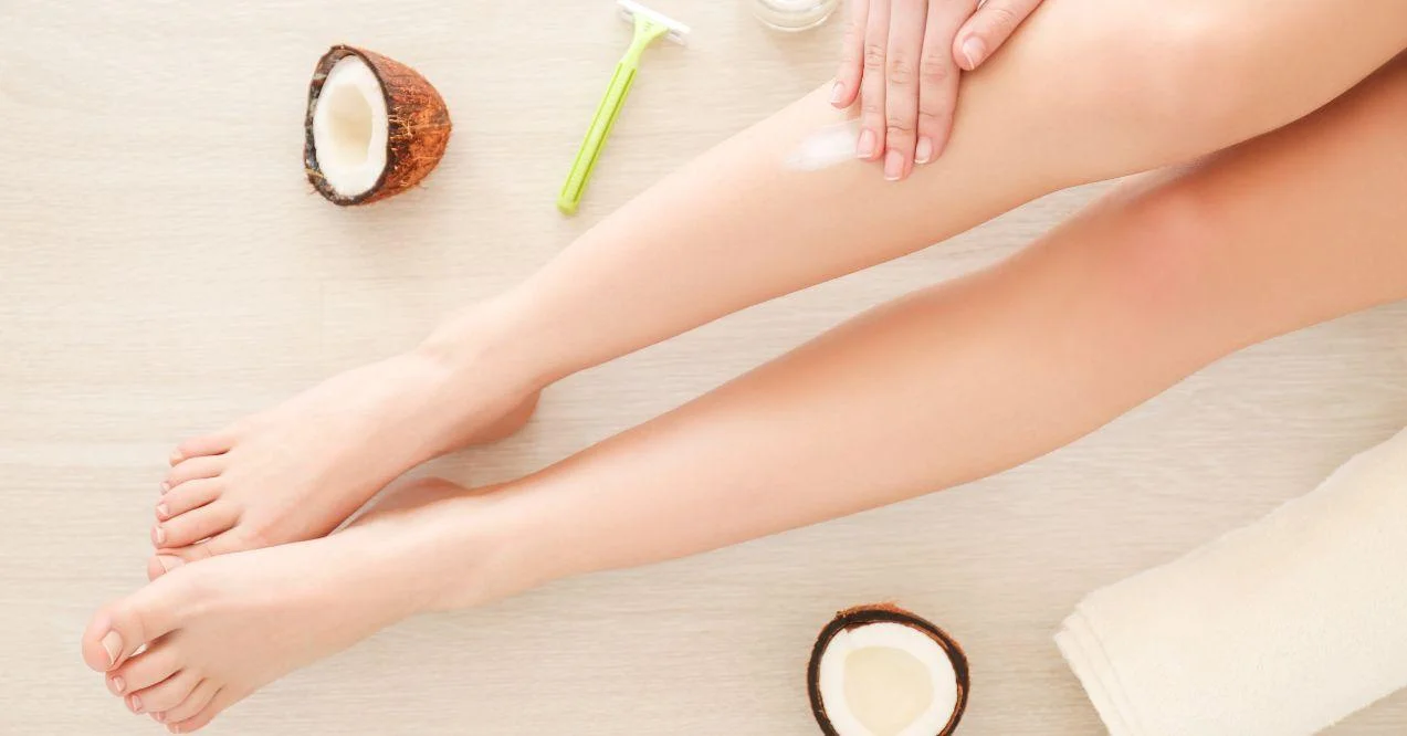 Woman applying coconut oil on legs to moisturize them
