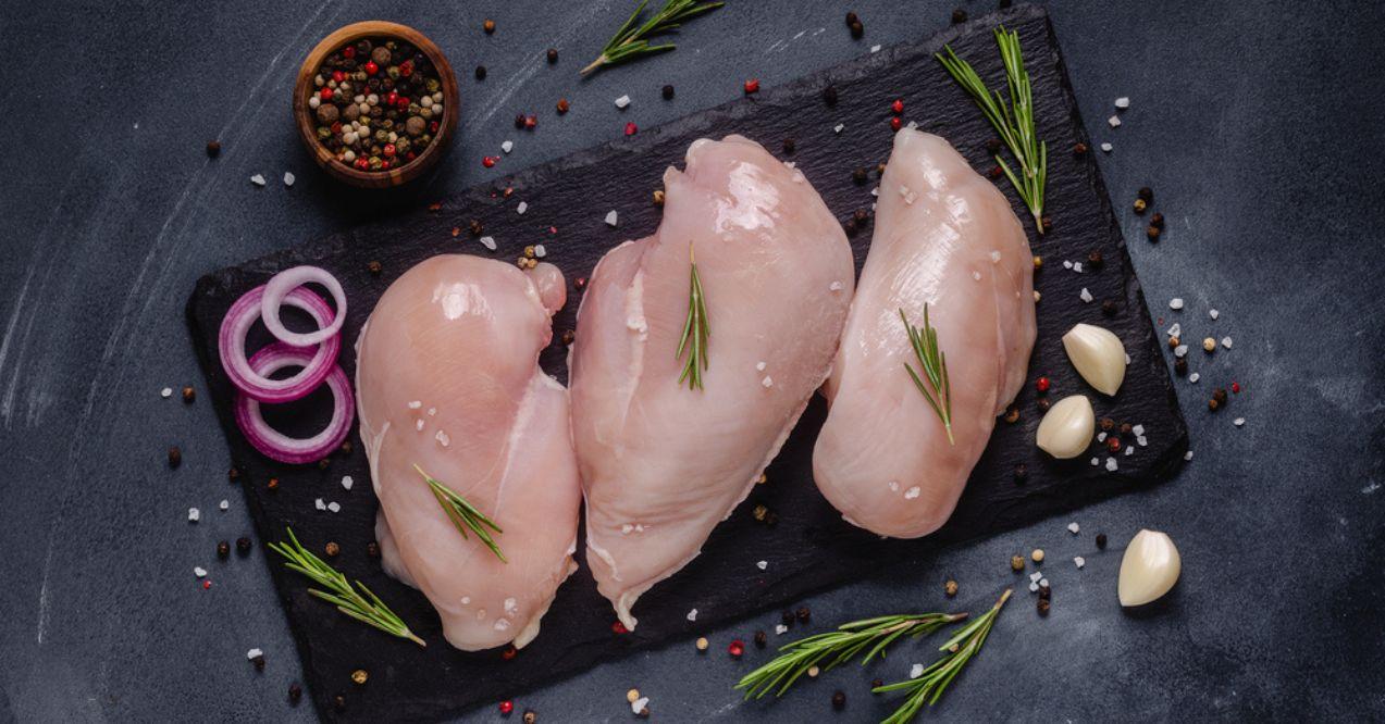 Raw chicken fillet with spices and herbs from top view