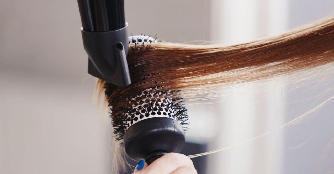 Hairdresser dries hair with a hairdryer in beauty salon
