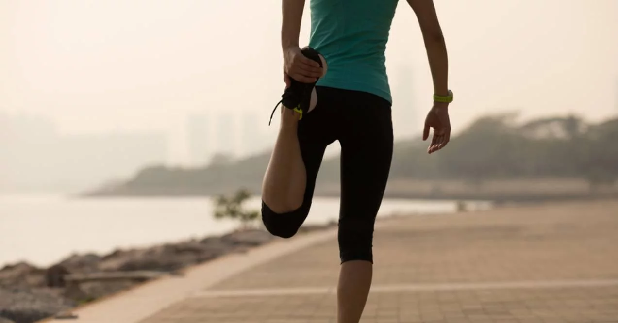 Fitness sportswoman warming up before running