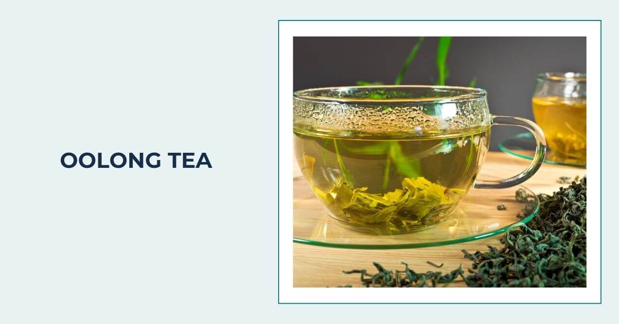 Glass cup of oolong tea with loose oolong leaves on a wooden surface.
