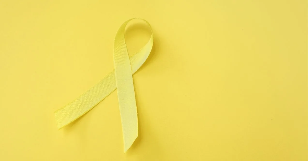 A close-up image of a yellow ribbon curled in a loop against a solid yellow background.