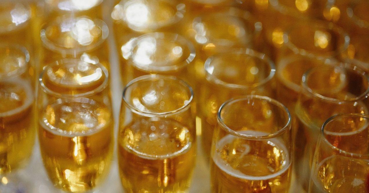 Close-up of multiple glasses filled with bubbly golden champagne, bubbles.
