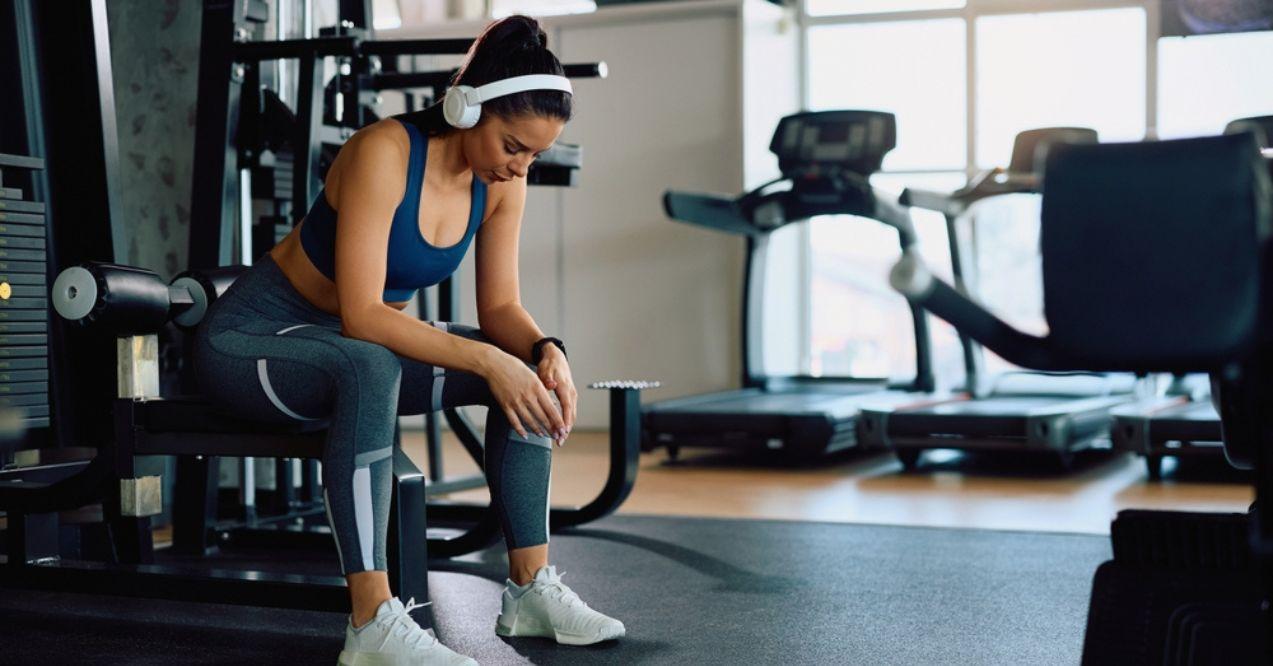 Exhausted sportswoman taking a break during exercise class in a gym.