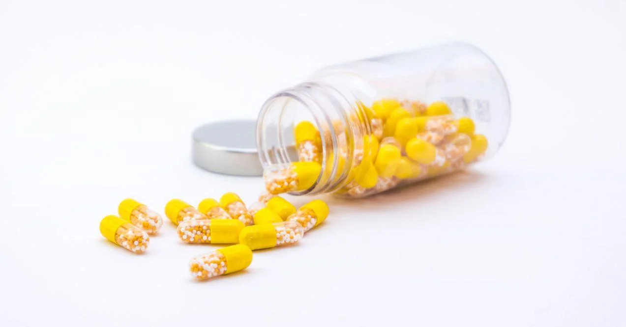 Open Container with spilled Vitamin D3 and K2 capsules