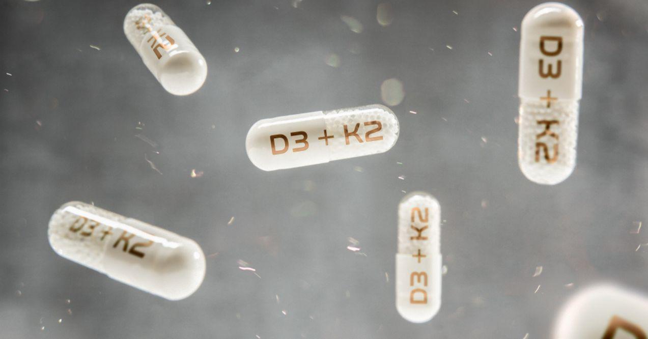 Pills float in the air with inscription D3 + K2 vitamins
