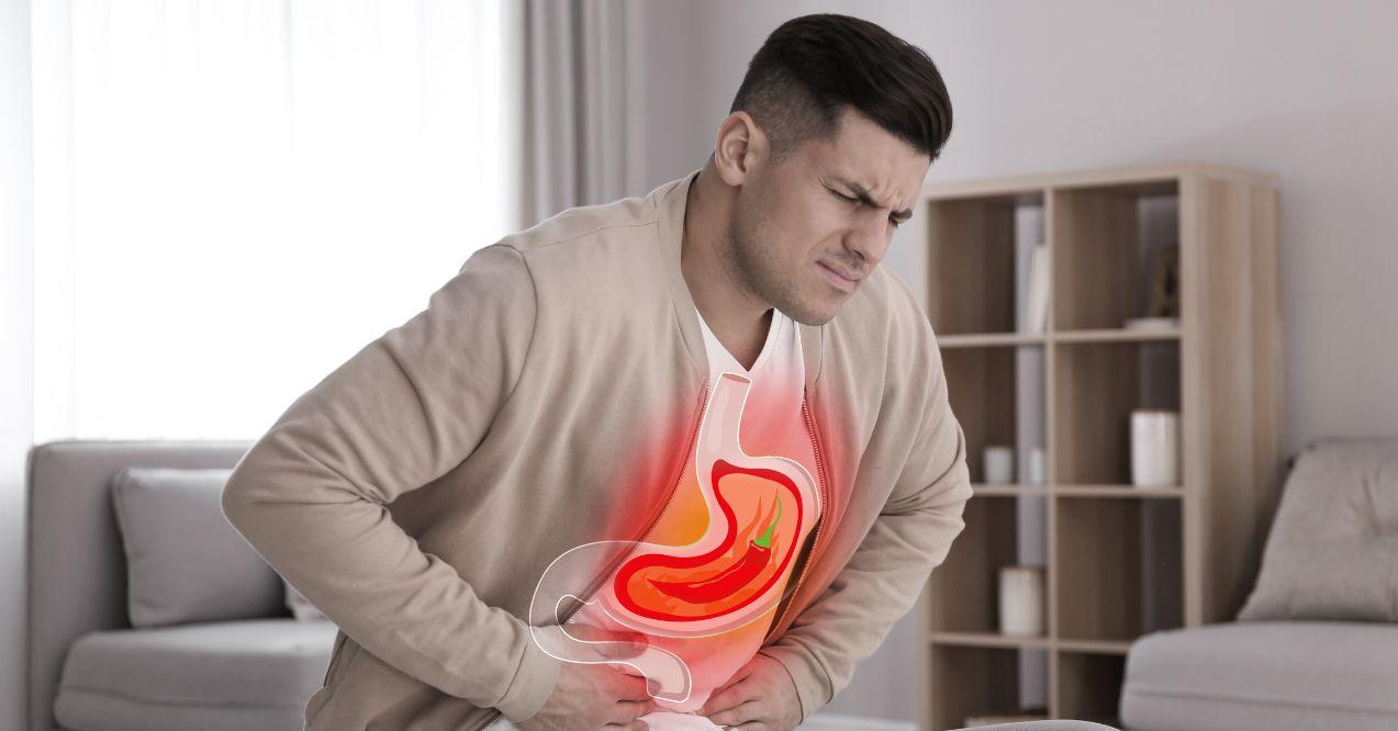 a man is experiencing heartburn with a graphic of the stomach displayed on his chest