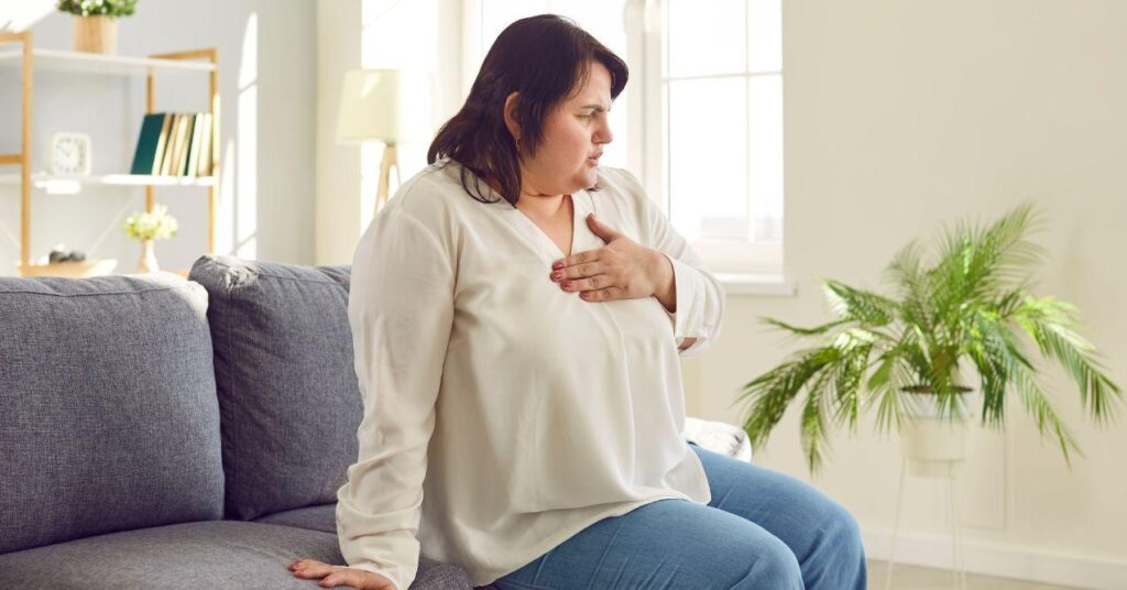 a woman is holding her hand on chest due to chest spasms