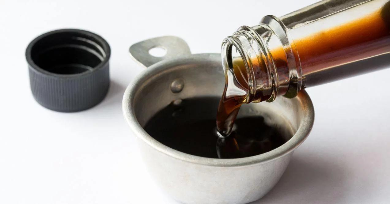 coconut aminos being spilled in a small metallic bowl