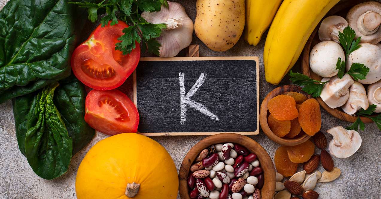 foods high in potassium, with the chemical symbol for potassium displayed on a small chalk board in the center