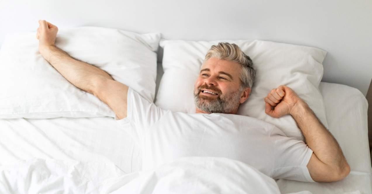 Happy smiling middle aged man waking up