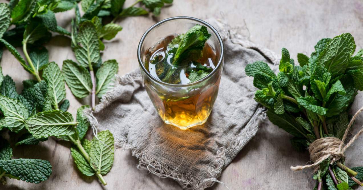 A glass of tea with fresh mint leaves