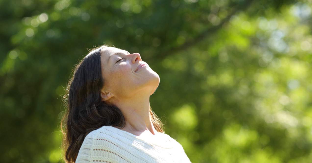 Relaxed middle age woman breathing fresh air