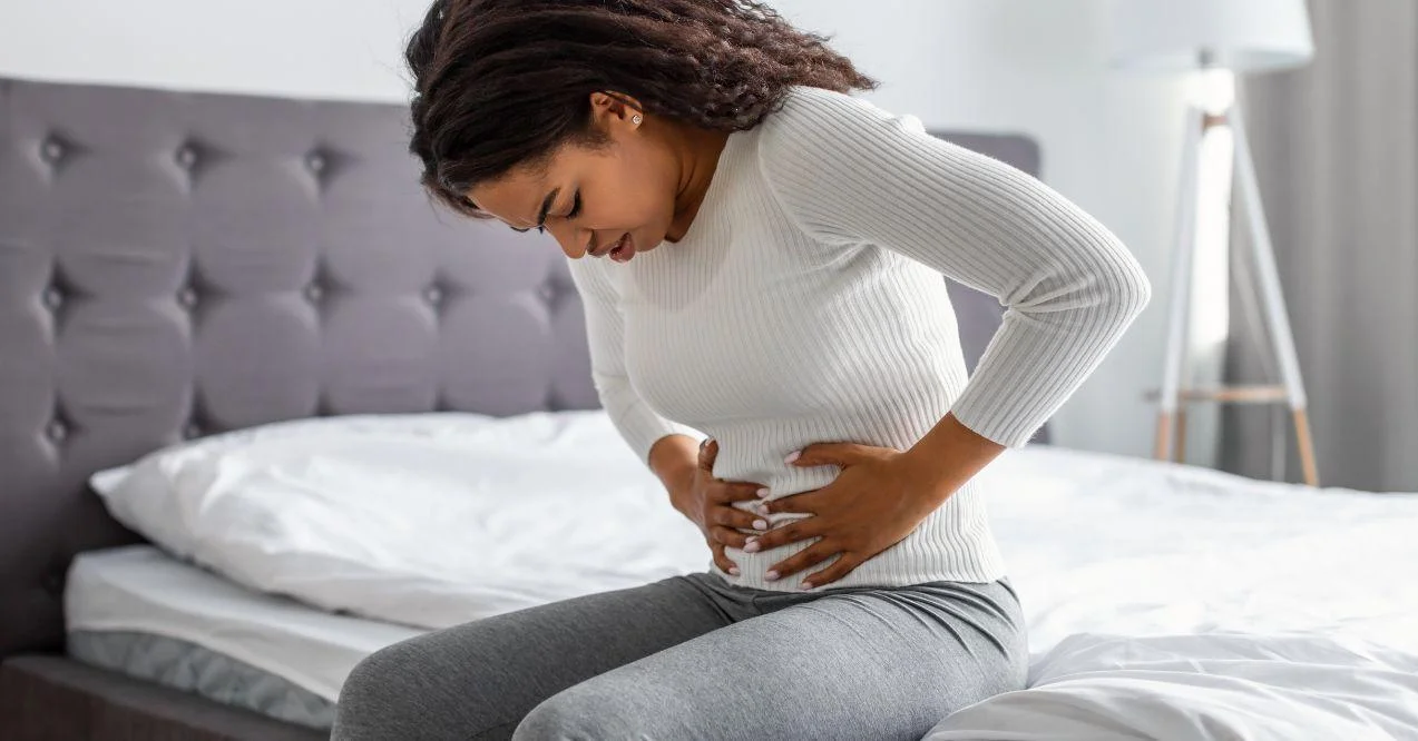 the woman is holding her belly due to uti pain