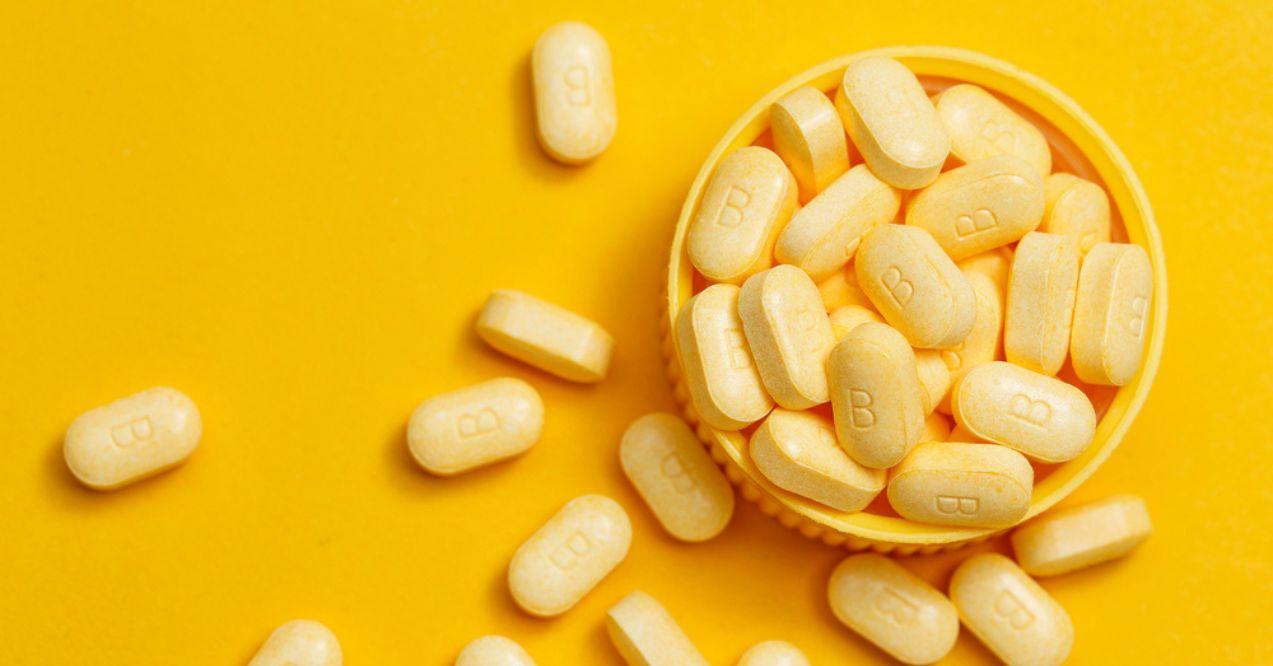 Vitamin B tablets on yellow background
