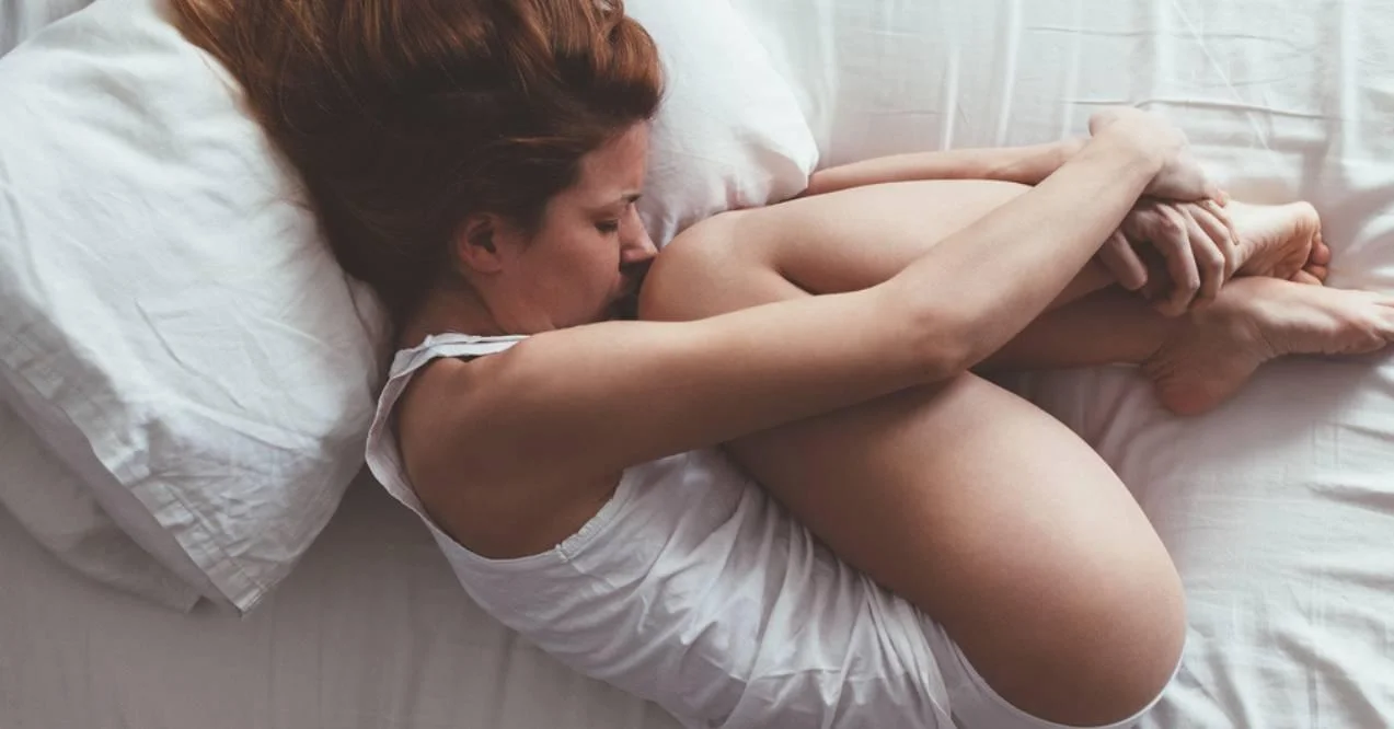 Woman curled up in bed