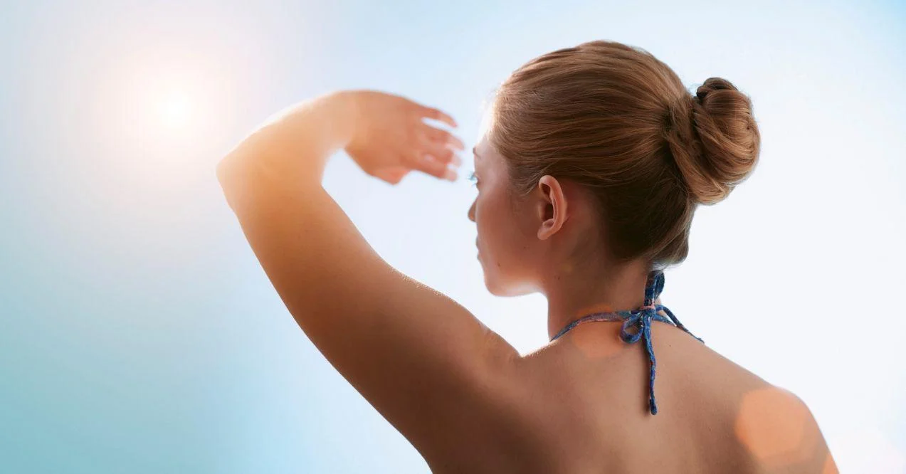 woman holding a hand and hiding from sun