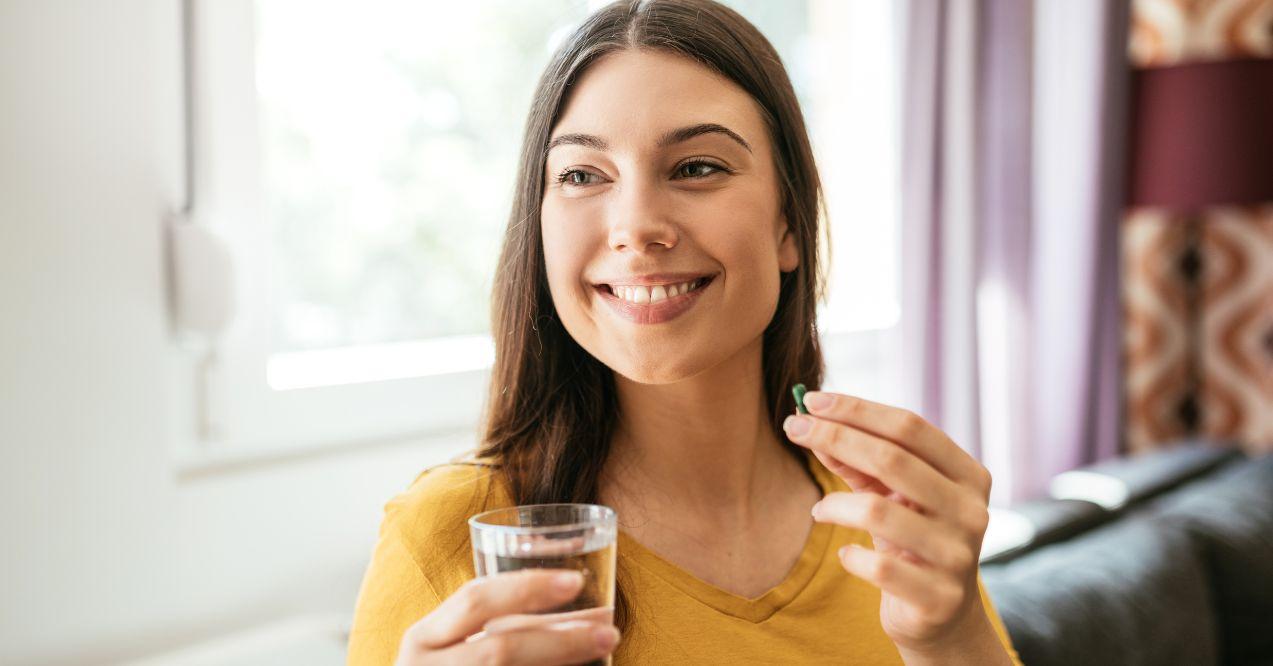woman is drinking a supplement pill