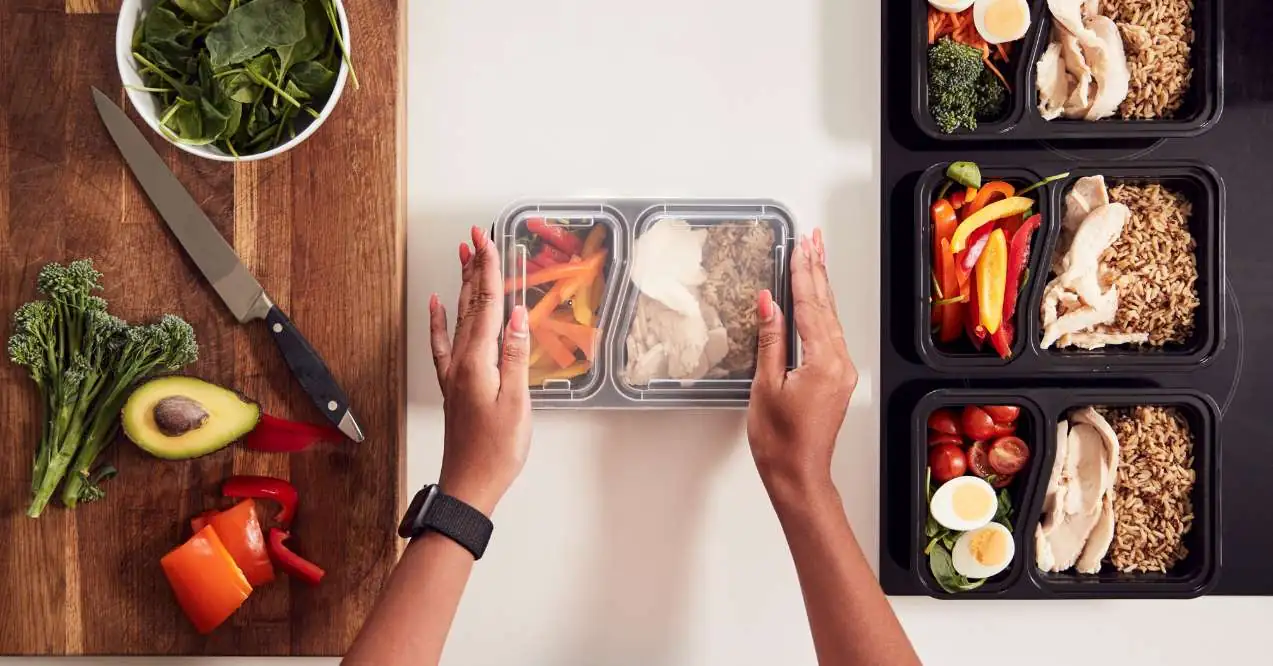 woman is holding a food container with prepared food