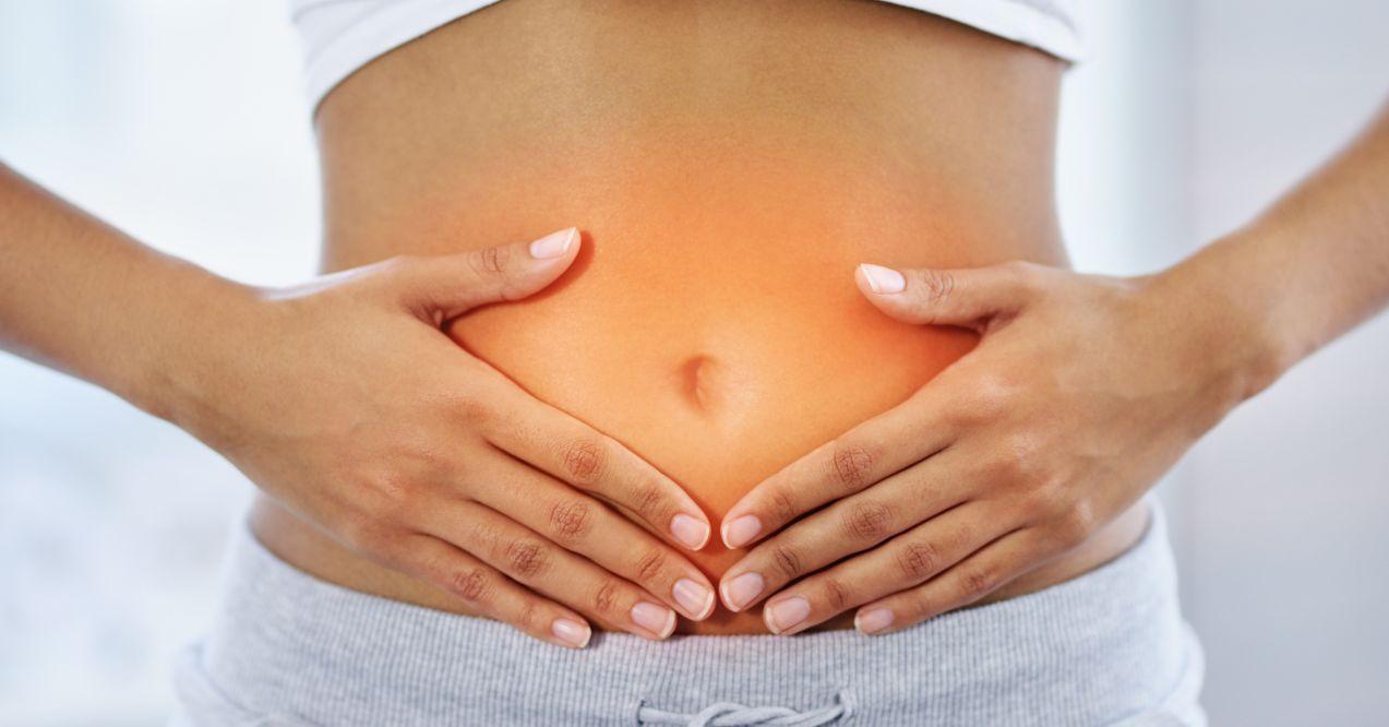 woman is holding her belly with both hands
