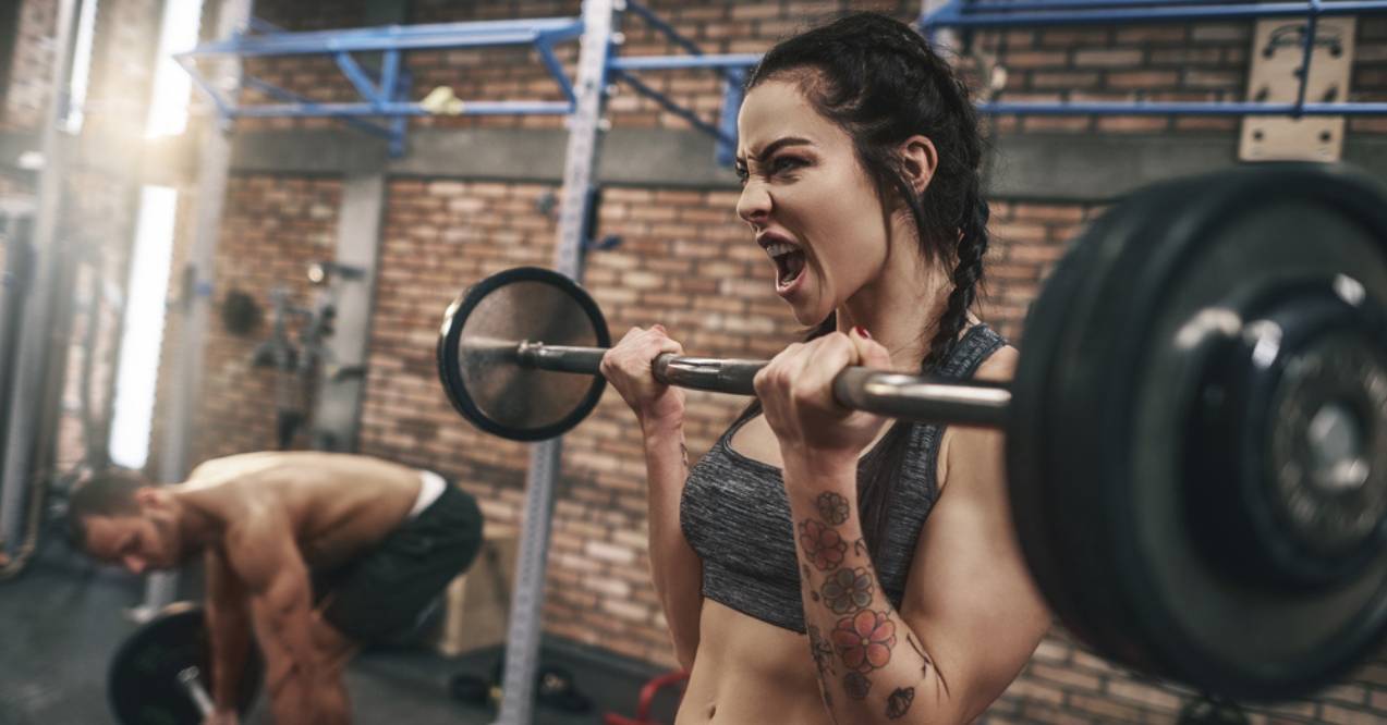 Woman lifting barbell in the gym