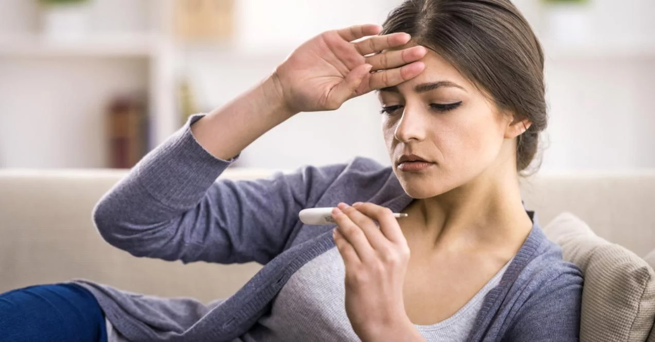 Young woman is looking at the thermometer