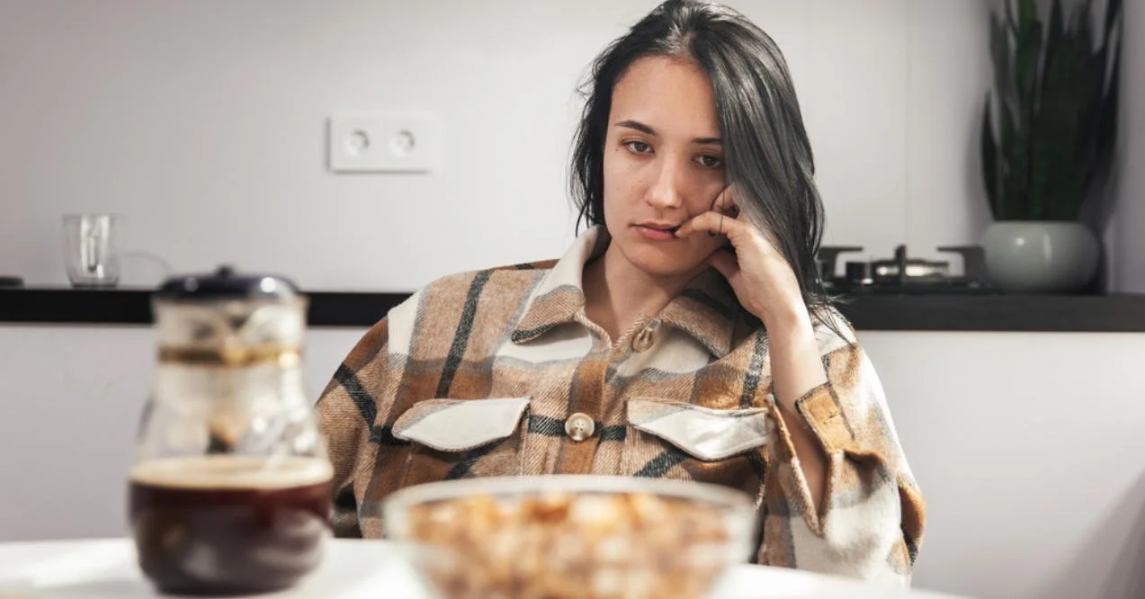 Woman looks at food without appetite
