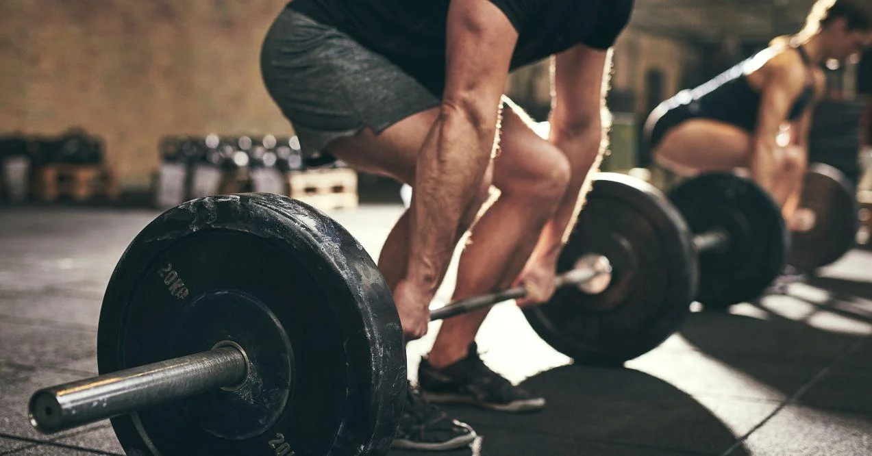 a man and a woman are doing a deadlift