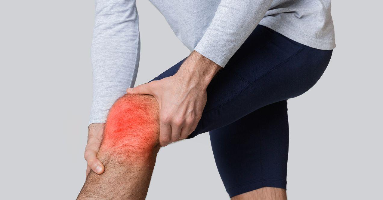 a man is holding his knee due to inflammation