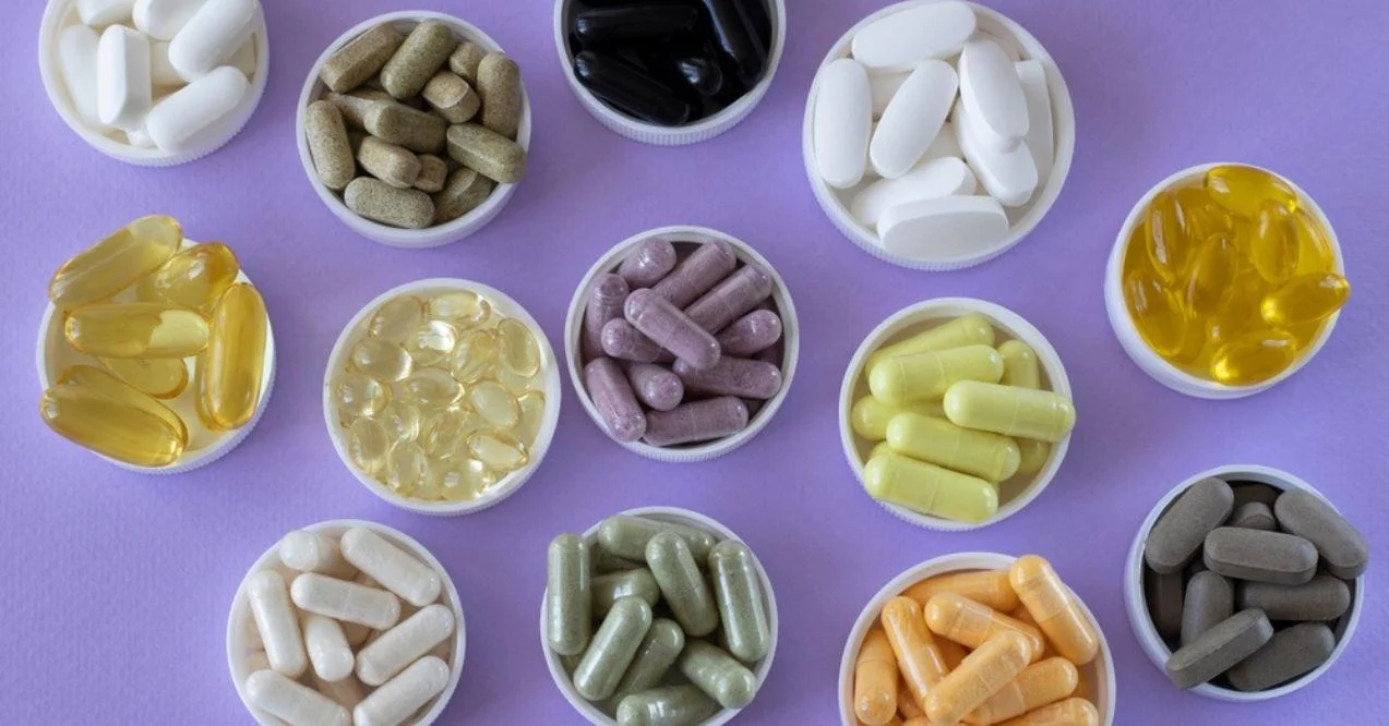 A collection of various dietary supplements in pill form in small containers