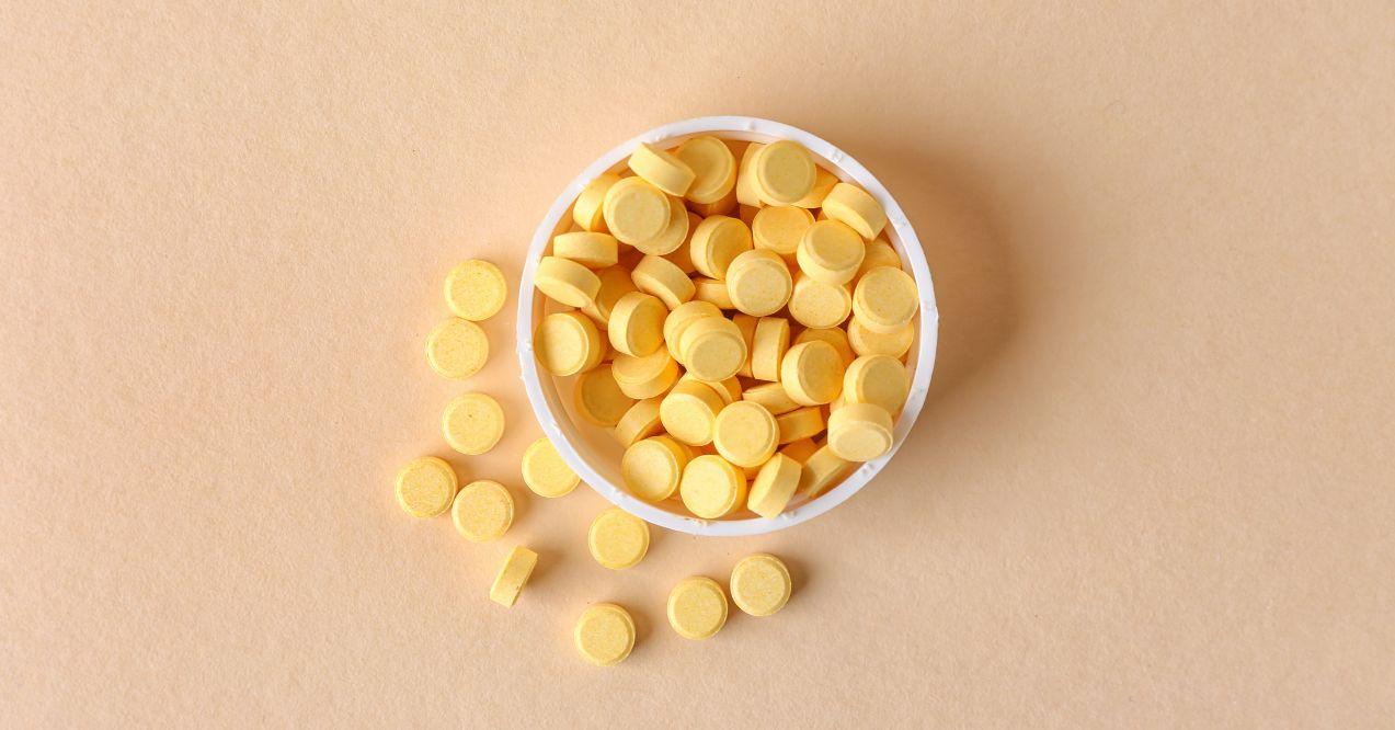 Folic Acid tablets spilled onto a beige surface