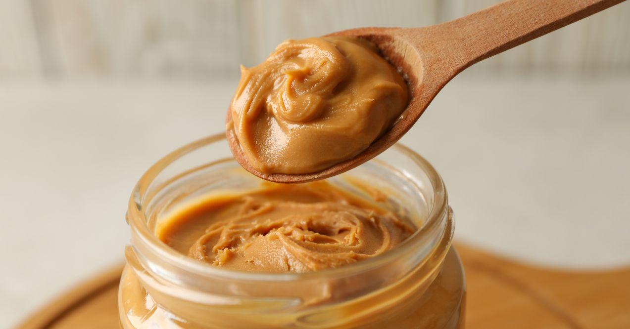 peanut butter is being taken from a jar with a spoon