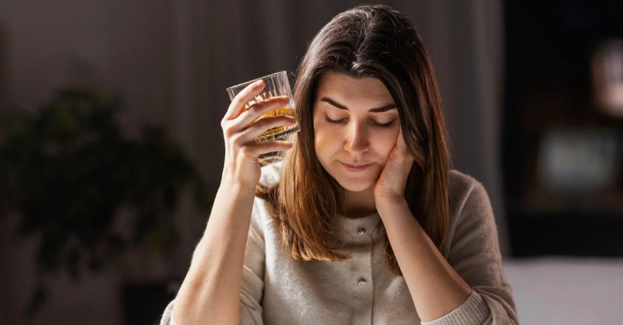Woman drinking alcohol at home