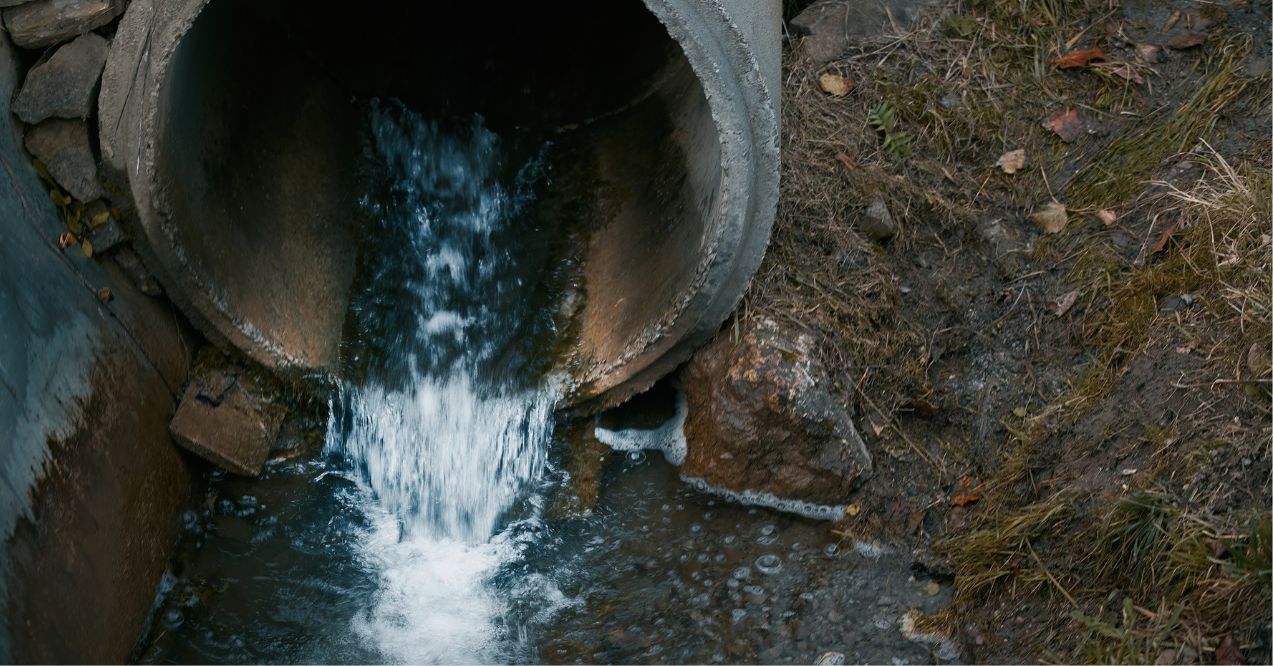 Draining sewage from a pipe into the river. Metaphor for lymphatic drainage