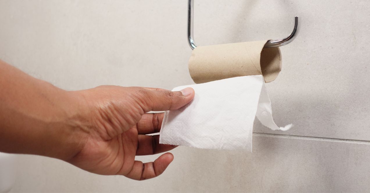 Hand pulling toilet paper roll in holder. Diahrrea and kidney stones..