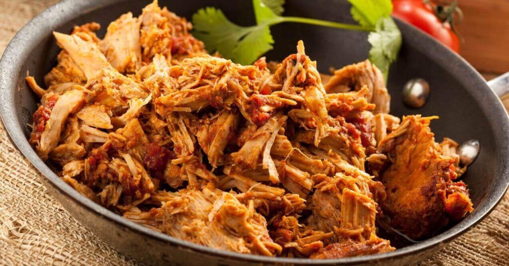 Keto-friendly Mexican shredded chicken in a skillet, seasoned and ready to serve.