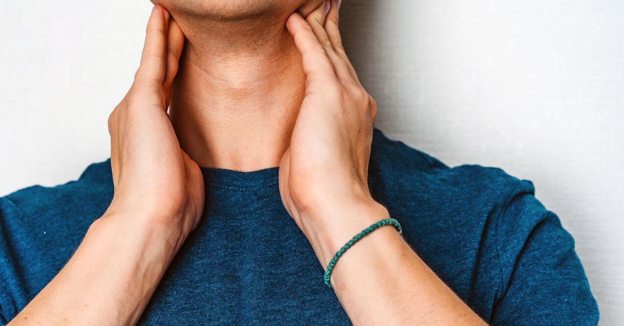 Close-up of a man touching both sides of his neck, checking for swollen lymph nodes.