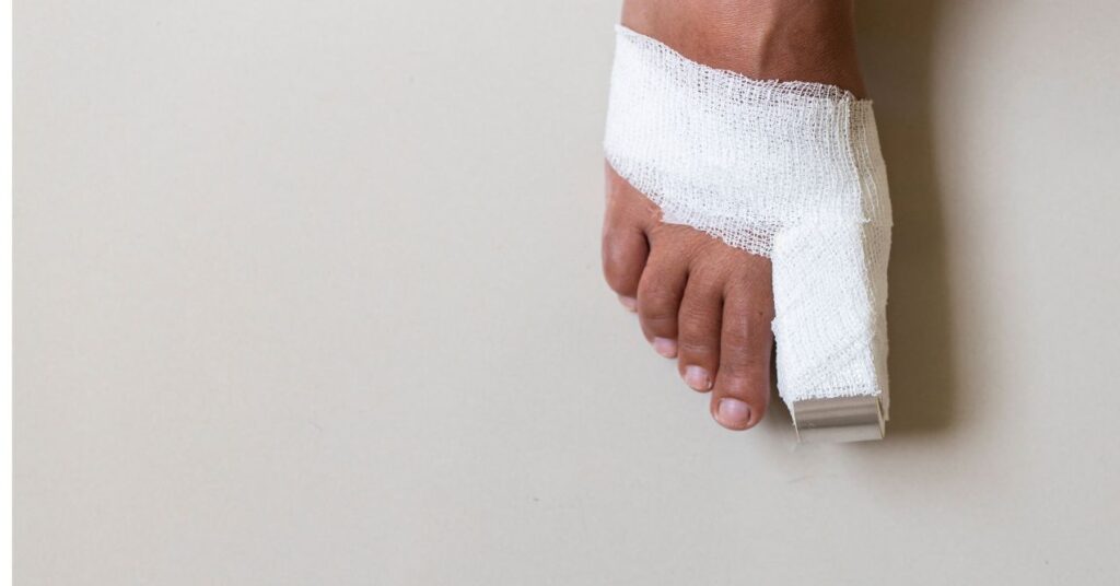 Foot with big toe bandaged on white background.