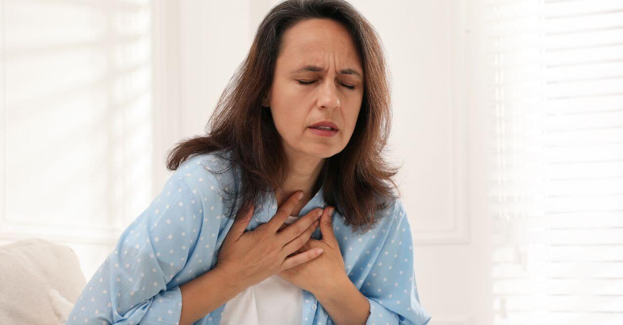 Middle-aged woman experiencing shortness of breath, illustrating the question: can liver disease cause shortness of breath?