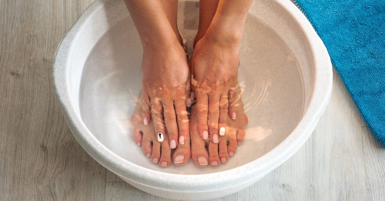 Feet soaking in a bowl of warm water for relaxation or treatment.