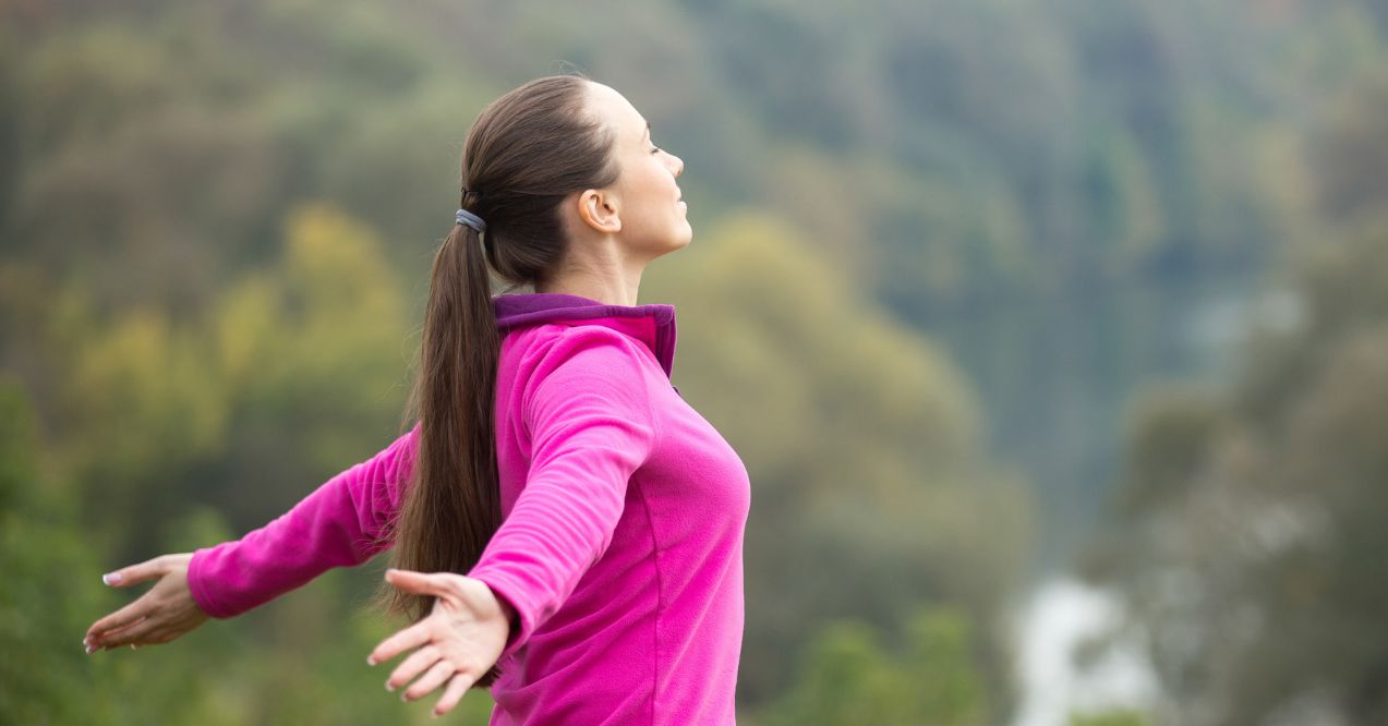 Young woman practicing a yoga pose outdoors, embracing mindfulness and enjoying nature.