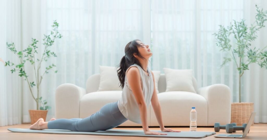 Woman practicing somatic exercises for weight loss in a yoga class with a serene background.