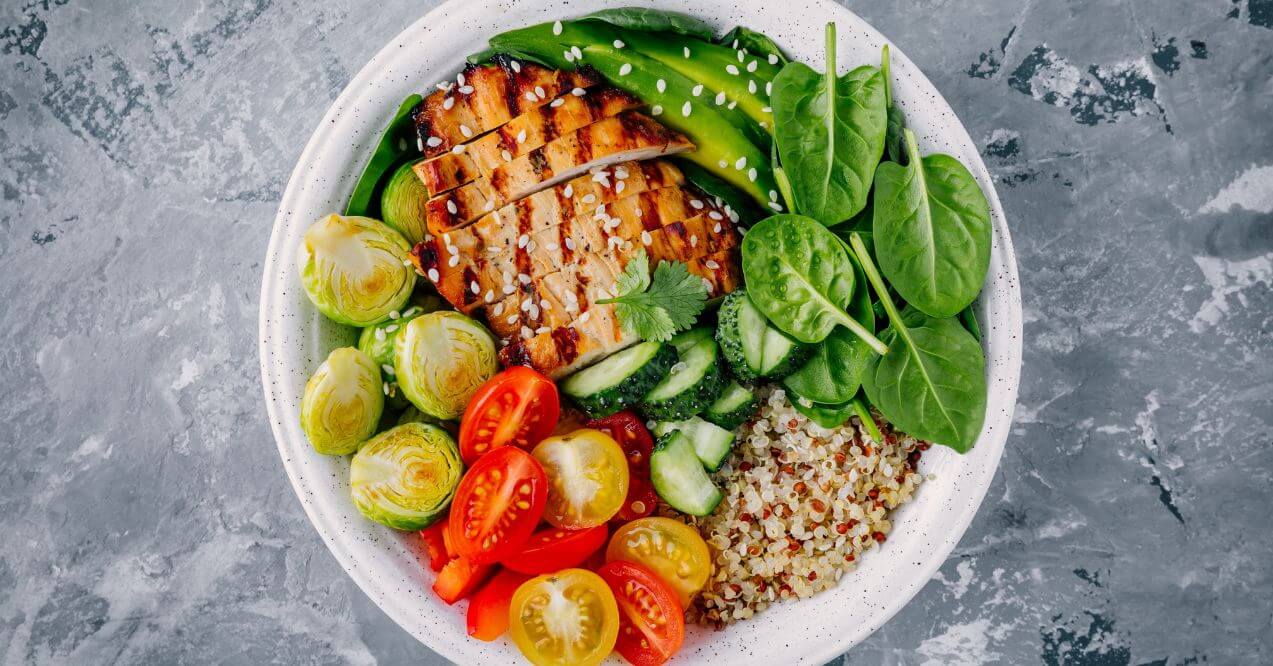 A vibrant salad bowl with grilled chicken, quinoa, and fresh veggies.