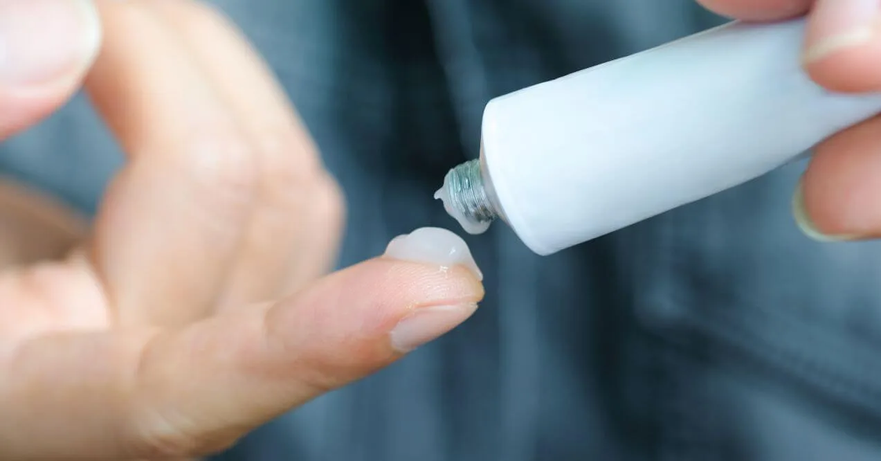 Hand applying an antifungal gel, focusing on effective skin care solutions.