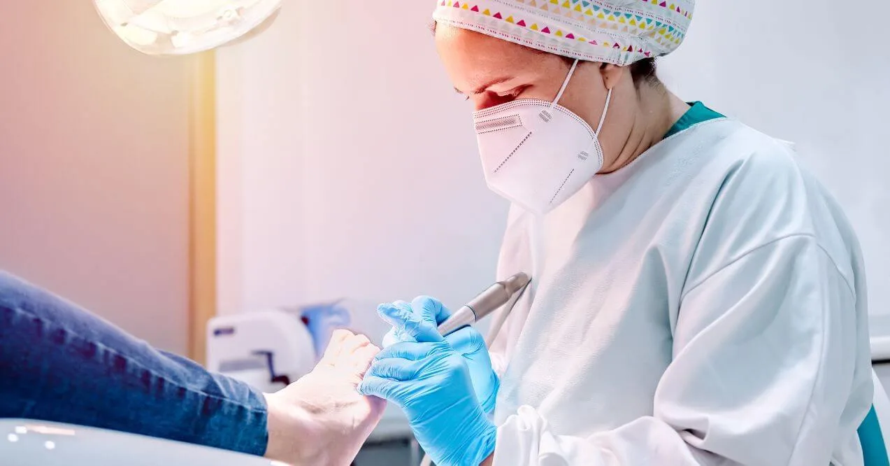 Podiatrist treating a patient for toe fungus using professional tools, highlighting 'podiatrist for toe fungus' services.