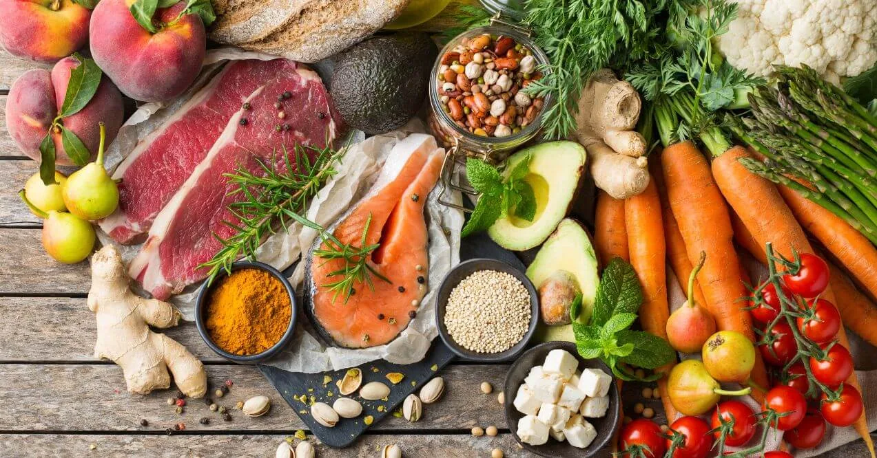 Variety of balanced nutrition foods on wooden table.