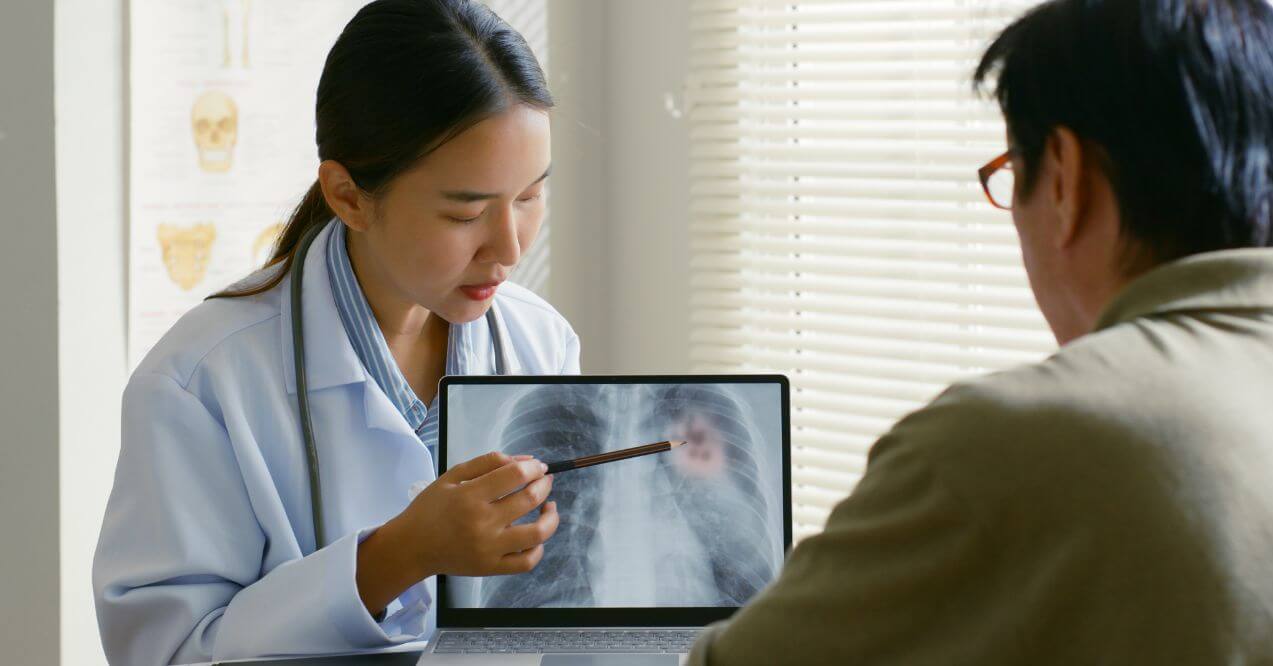 Doctor discussing a lung X-ray with a patient during a health consultation.